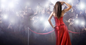 Celebridad en vestido rojo capturada por fotógrafos en un evento de alfombra roja, destacando en Noticias Celebrities y eventos de celebrities en SpykPress.com.