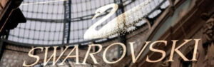 Logotipo de Swarovski con un cisne cubierto de cristales, representando la alta calidad y el diseño innovador de la empresa multinacional en el mundo de la moda y joyería de cristal.