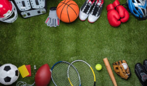 Artículos deportivos variados incluyendo pelota de fútbol, raqueta de tenis, balón de baloncesto y guantes de boxeo, representando Noticias Deportes.