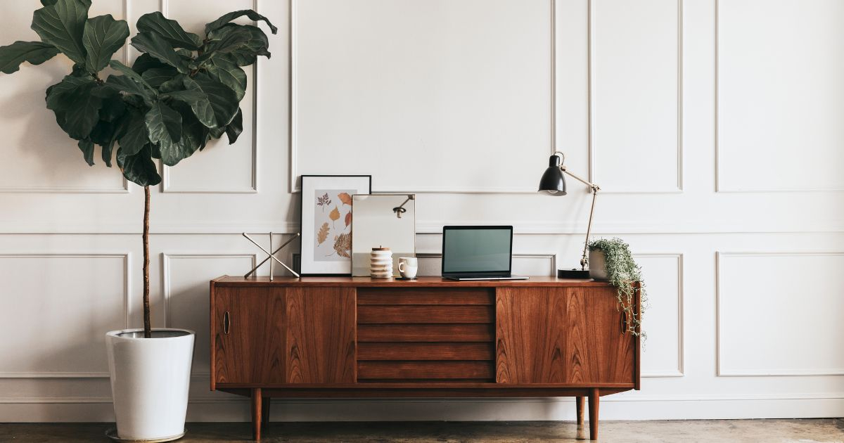 Estilo mid century moderno muebles modernos muestra un elegante mueble de madera junto a una planta, representando estilo mid century moderno y diseño sofisticado. Esta imagen es adecuada para artículos sobre muebles modernos, diseño danés y decoración de interiores.
