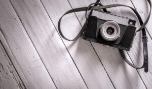 Noticias Fotografía - Cámara vintage sobre superficie de madera clara representando la evolución y nostalgia en la fotografía y actualidad fotográfica.