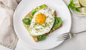 Tostada con huevo frito, espinacas y especias, mostrando las últimas tendencias en Noticias Gastronomía.