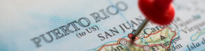 Detalle de un mapa de Puerto Rico con un pin rojo señalando San Juan, ilustrando los destinos turísticos en Puerto Rico.