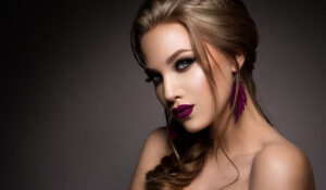 Modelo con maquillaje dramático y pendientes largos, destacando las últimas Noticias Moda y tendencias de moda.