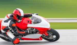 Piloto de motociclismo en acción durante una carrera, destacando en Noticias Motociclismo.