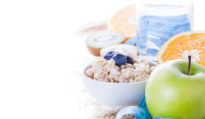 Desayuno saludable con avena, manzana, naranja y agua, destacando en Noticias Nutrición.