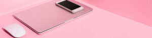Laptops Color Rosa y Accesorios - La imagen muestra una laptop, un teléfono móvil y un ratón sobre una superficie de color rosa. Ideal para aquellos que buscan portátiles rosas y accesorios que complementen su estilo con elegancia y modernidad.