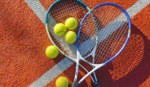 Raquetas y pelotas de tenis sobre una cancha, representando las últimas Noticias Tenis mundial.