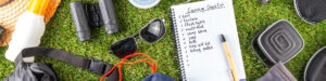 Fotografía de equipo esencial para camping familiar con lista de verificación de artículos de camping, binoculares y otros accesorios, ideal para vacaciones en camping.